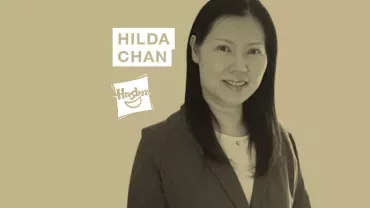 A person in professional attire with text 'Hilda Chan' and a logo in the background.