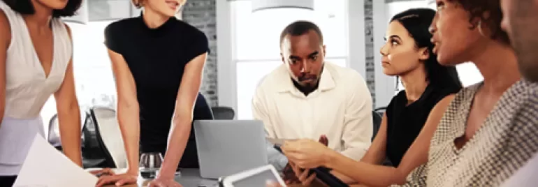 A diverse group of people having a meeting around a table.