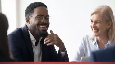 Colleagues smiling in a meeting.